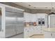 Modern kitchen with stainless steel appliances, white cabinets, and brick backsplash at 9390 Stange Ave, Las Vegas, NV 89129