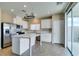 Modern kitchen with white cabinets, stainless steel appliances, a large island with marble countertops, and tile floors at 9529 Windsor Forest Ct, Las Vegas, NV 89123