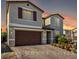 Two-story home featuring a brick driveway, stucco exterior, shutters, and a two-car garage at 10963 Mount Goyer St, Las Vegas, NV 89141