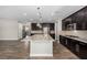Spacious kitchen featuring an island with granite countertops, stainless appliances, and dark wood cabinets at 10963 Mount Goyer St, Las Vegas, NV 89141