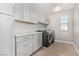 Laundry room with gray cabinets, a gray countertop, shelving, and a front-load washer and dryer at 10963 Mount Goyer St, Las Vegas, NV 89141