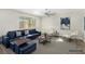 Staged living room with blue sofa, chairs, modern rug, fan, and natural light at 10963 Mount Goyer St, Las Vegas, NV 89141