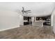 Open floor plan living room with a large fan, wood-look tile flooring, and modern kitchen at 10963 Mount Goyer St, Las Vegas, NV 89141