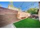 Private backyard featuring a tall brick fence, artificial turf, and a charming patio with comfortable furniture at 10990 Mountain Willow St, Las Vegas, NV 89179