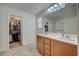This bathroom features a double sink vanity, tile floors, and an adjacent walk-in closet at 10990 Mountain Willow St, Las Vegas, NV 89179