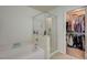 A bathroom with a shower and bathtub, next to a well-organized walk-in closet at 10990 Mountain Willow St, Las Vegas, NV 89179