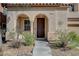 Charming front entrance featuring a covered porch with archways and a well-maintained landscaped yard at 10990 Mountain Willow St, Las Vegas, NV 89179