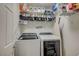 Functional laundry room with modern appliances, wire racks, and storage shelves at 10990 Mountain Willow St, Las Vegas, NV 89179
