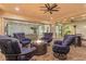 Cozy covered back patio featuring a fire pit, comfortable seating, and stylish ceiling fans at 12169 Castilla Rain Ave, Las Vegas, NV 89138