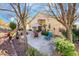 Backyard patio with mature landscaping including a stone patio, table, chairs, and desert landscaping at 1312 Rolling Sunset St, Henderson, NV 89052