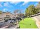 A backyard view showcasing a small putting green, outdoor patio, and desert landscaping in a secure area at 1312 Rolling Sunset St, Henderson, NV 89052