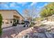 Backyard with desert landscaping, mature trees, a stone patio, and dining furniture, creating a serene oasis at 1312 Rolling Sunset St, Henderson, NV 89052