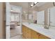 Bathroom featuring double sinks, light wood cabinets, and mirrors at 1312 Rolling Sunset St, Henderson, NV 89052