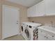 Spacious laundry room with a washer, dryer, and cabinets at 1312 Rolling Sunset St, Henderson, NV 89052