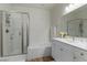 Clean bathroom featuring a shower over tub, glass door, and white vanity with plenty of storage at 1410 Pink Dawn Dr, Henderson, NV 89014