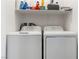 Bright laundry room featuring a washer, dryer, and convenient overhead shelving at 1410 Pink Dawn Dr, Henderson, NV 89014