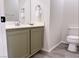 This half bath features an olive vanity and gray wood-look flooring at 1960 Verbania Dr, Las Vegas, NV 89134