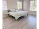A bedroom featuring a queen bed with gray laminate flooring and two large windows for natural light at 1960 Verbania Dr, Las Vegas, NV 89134