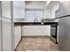 Modern kitchen featuring stainless steel appliances, white cabinets, dark countertops and tile floors at 1960 Verbania Dr, Las Vegas, NV 89134
