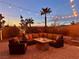 Inviting backyard patio with cozy seating around a fire pit and string lights at dusk at 2436 Chateau Napoleon Dr, Henderson, NV 89044