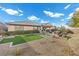 Large backyard featuring a manicured artificial lawn, mature landscaping, and charming water feature at 2436 Chateau Napoleon Dr, Henderson, NV 89044