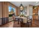 Bright dining room with a round wooden table, chandelier, and a view of the backyard at 2436 Chateau Napoleon Dr, Henderson, NV 89044