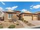 Charming home featuring stone accents, desert landscaping, and a three-car garage at 2436 Chateau Napoleon Dr, Henderson, NV 89044