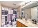 A standard bathroom with a tile backsplash, vanity, toilet, and patterned shower curtain at 328 S Buffalo Dr # 101, Las Vegas, NV 89145