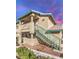 Beige two-story condo featuring a staircase leading to the upper unit and desert landscaping at 328 S Buffalo Dr # 101, Las Vegas, NV 89145
