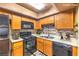 A kitchen features an oven, microwave, wooden cabinets, tile backsplash and countertops at 328 S Buffalo Dr # 101, Las Vegas, NV 89145