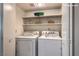 Bright laundry area with washer, dryer, and built-in shelving for organized storage at 328 S Buffalo Dr # 101, Las Vegas, NV 89145