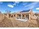 Backyard featuring a patio area, gravel landscaping, and solar panels on the roof at 3305 Fernbird Ln, North Las Vegas, NV 89084