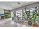 Bright dining area with a wooden table, stylish chairs, lots of windows and plant accents at 3305 Fernbird Ln, North Las Vegas, NV 89084