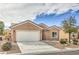 Charming single-story home with a two-car garage, desert landscaping, and a tile roof at 3305 Fernbird Ln, North Las Vegas, NV 89084