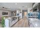 Open concept kitchen with stainless steel appliances, white cabinets, tile backsplash, and wood flooring at 3305 Fernbird Ln, North Las Vegas, NV 89084