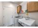 Functional laundry room with washer, dryer, and overhead cabinets for storage at 3305 Fernbird Ln, North Las Vegas, NV 89084