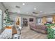 Open-concept living room featuring a dining area, comfortable seating, wood-look tile flooring, and modern decor at 3305 Fernbird Ln, North Las Vegas, NV 89084