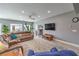 Open-concept living room featuring a large sectional sofa, wood floors, and plenty of light at 3305 Fernbird Ln, North Las Vegas, NV 89084