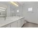 A bright bathroom features double sinks with brushed nickel faucets and a large mirror at 3425 Conan St # 103, Las Vegas, NV 89129