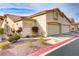 Exterior shot of a home showing the two car garage, desert landscaping, and red-tiled roof at 3425 Conan St # 103, Las Vegas, NV 89129