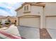 Exterior view of a two-car garage with beige doors and a red tile roof on a sunny day at 3425 Conan St # 103, Las Vegas, NV 89129