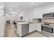 Open concept kitchen with stainless appliances, island, white cabinets and countertops at 3425 Conan St # 103, Las Vegas, NV 89129