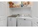 Functional laundry room with modern washer and dryer units and overhead shelving at 3425 Conan St # 103, Las Vegas, NV 89129