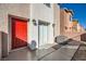 Exterior view of the side of the home with a red front door and small yard at 4052 Rocky Beach Dr, Las Vegas, NV 89115