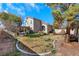 Spacious backyard featuring a grassy area, mature trees, and a basketball hoop, perfect for outdoor activities at 409 Rutherford Cir, Las Vegas, NV 89123