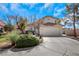 Charming two-story home with a red tile roof, well-manicured landscaping, and attached two car garage at 409 Rutherford Cir, Las Vegas, NV 89123