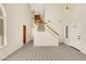 Bright foyer with tiled flooring, high ceilings, a staircase with wood railing, and modern chandeliers at 409 Rutherford Cir, Las Vegas, NV 89123