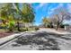 Quiet street featuring a well-maintained home with desert landscaping and mature trees at 409 Rutherford Cir, Las Vegas, NV 89123