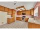 A sunlit kitchen featuring tile floors, wood cabinets, white countertops, and stainless steel appliances at 409 Rutherford Cir, Las Vegas, NV 89123