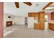 Open-concept living space featuring tile floors, a brick fireplace, and a partial view of the kitchen at 409 Rutherford Cir, Las Vegas, NV 89123